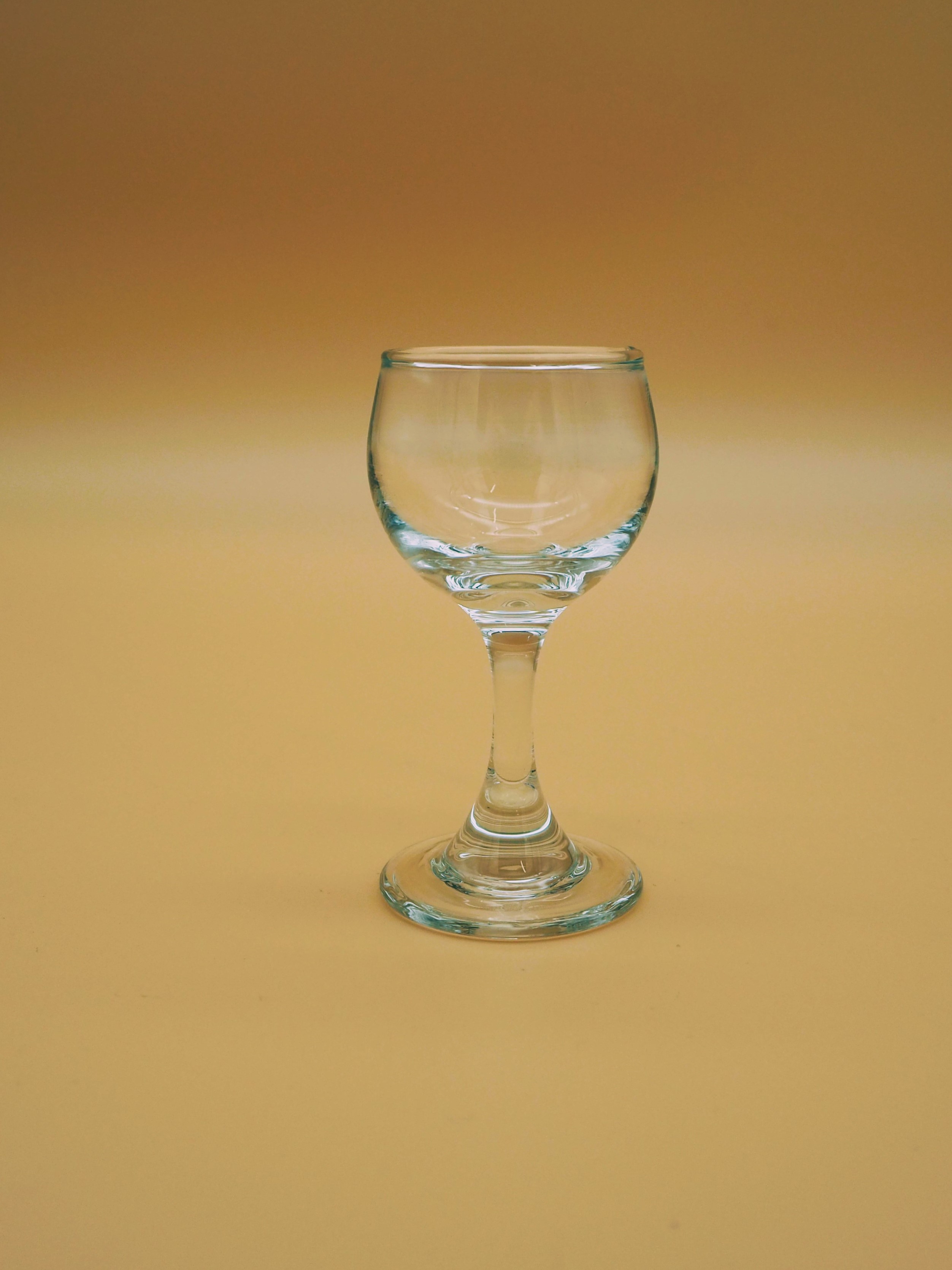 Eight shirts arranged on table in black, olive, grey, blue, white, red, mustard, and green.