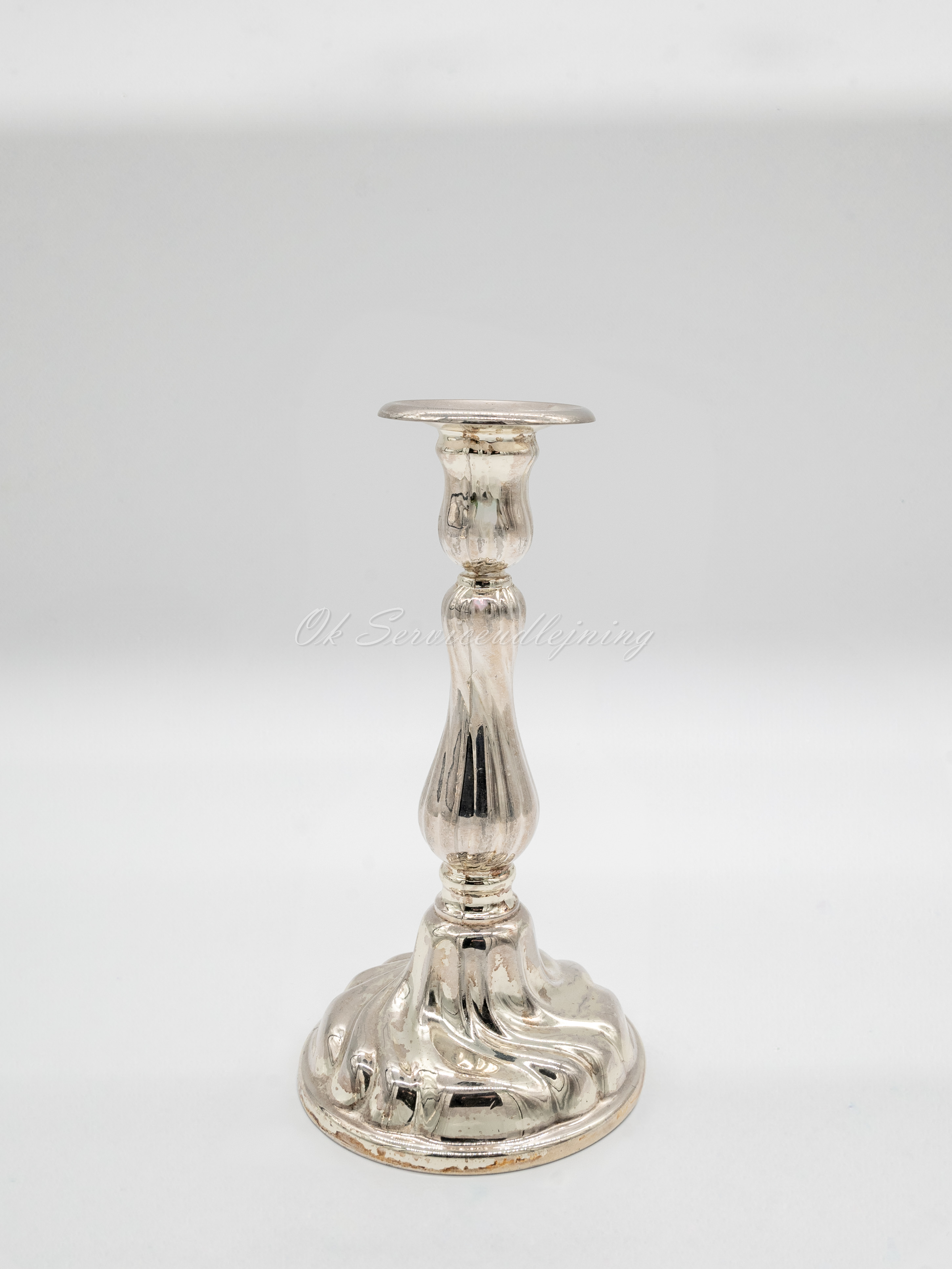 Eight shirts arranged on table in black, olive, grey, blue, white, red, mustard, and green.