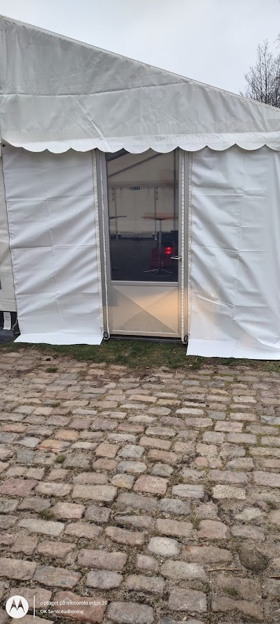 Eight shirts arranged on table in black, olive, grey, blue, white, red, mustard, and green.